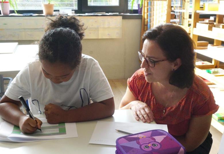 Sabrina Gerth begleitet ein Kind beim Schreibprozess.